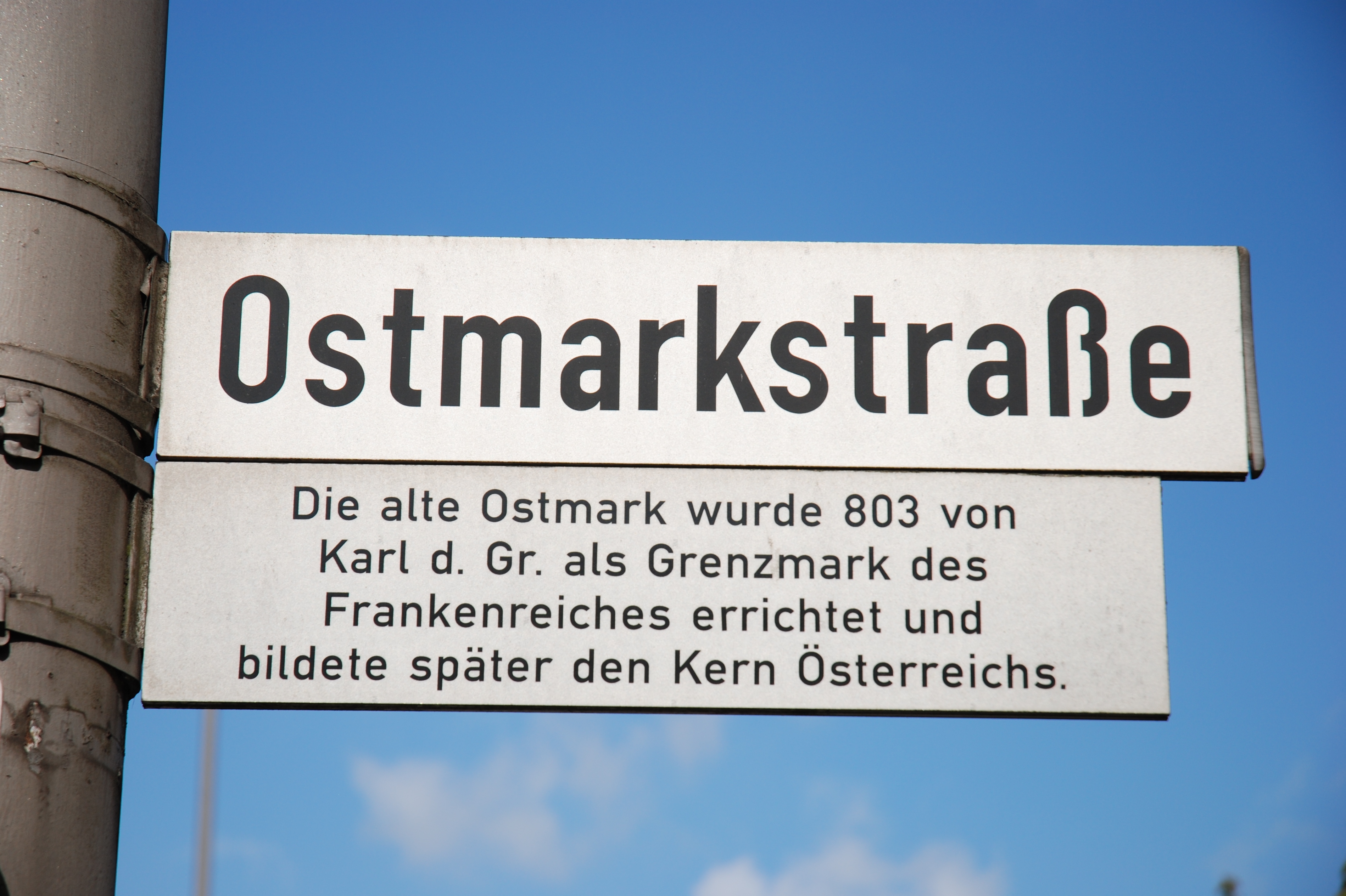 Straßenschild mit Straßenname Ostmarkstraße und Erklärtafel