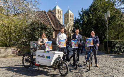 4 Personen halten das Stadtradeln Poster hoch und stehen vor dem Dom