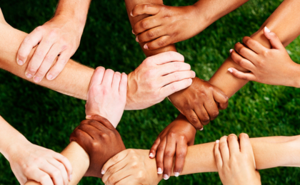 Verschiedene Hände und Arme greifen ineinander