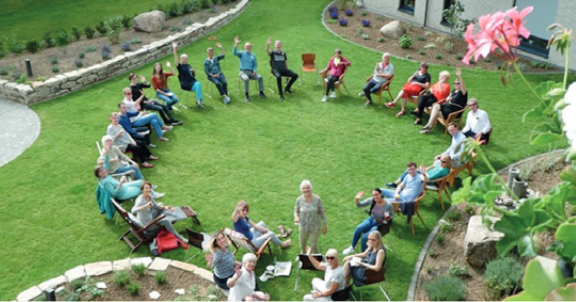 Kreis von Menschen in einem Garten