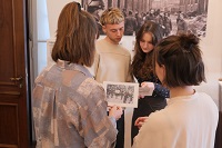 Yad Vashem Lecture am 30.4. Menschen stehen in einer Ausstellung um ein Bild