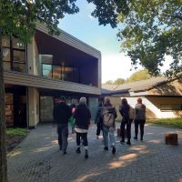 Teamende der Villa ten Hompel und des Franz-Hitze-Haus gehen auf den Eingang der Gedenkstätte Westerbork zu.