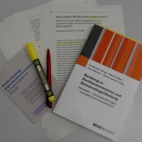 Auf einem Schreibtisch liegen der Sammelband und ein Ausdruck des Aufsatzes