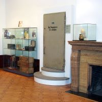 In einem der Ausstellungsräume der Villa ten Hompel finden sich Vitrinen und steht eine Bunkertür an der Wand.