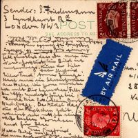 Auf der Rückseite einer Postkarte mit mehreren Briefmarken ist in kleiner Schrift ein Text geschrieben.