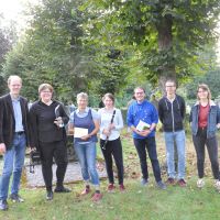 Die Mitwirkenden stehen, teils mit ihren Instrumenten, nebeneinander