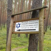 Hinweisschild auf Massengräber im Wald von Józefów