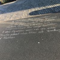mit Kreide geschriebener Informationstext auf der Straße