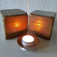 zwei durch eine Kerze beleuchtete Stolpersteine