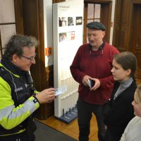 Der uniformierte Polizist Rainer Stoye kontrolliert gefälschte Pässe von zwei Schülerinnen, die rechts neben ihm und dem Künster Ruppe Koselleck stehen