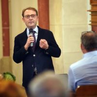 Stefan Querl redend mit einem Mikrofon in der Kirche