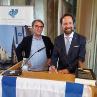 Stefan Querl und Michael Borchard stehen nebeneinander hinter einem Redepult