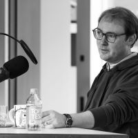 Stefan Querl vor einem Mikrofon bei der Podcast-Aufnahme