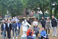 Teilnehmende Schülerinnen und Schüler neben Moderatorinnen und Moderatoren und Ausstellungsplakaten