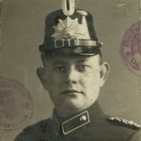 Ein Mann blickt in die Kamera.
Er trägt eine Uniform.