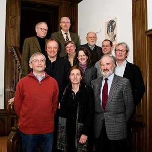 Elf Personen stehen auf einer Treppe in einem historischen Haus.