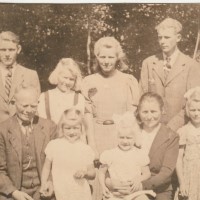 Historisches Gruppenfoto mit neun Personen in einem Garten
