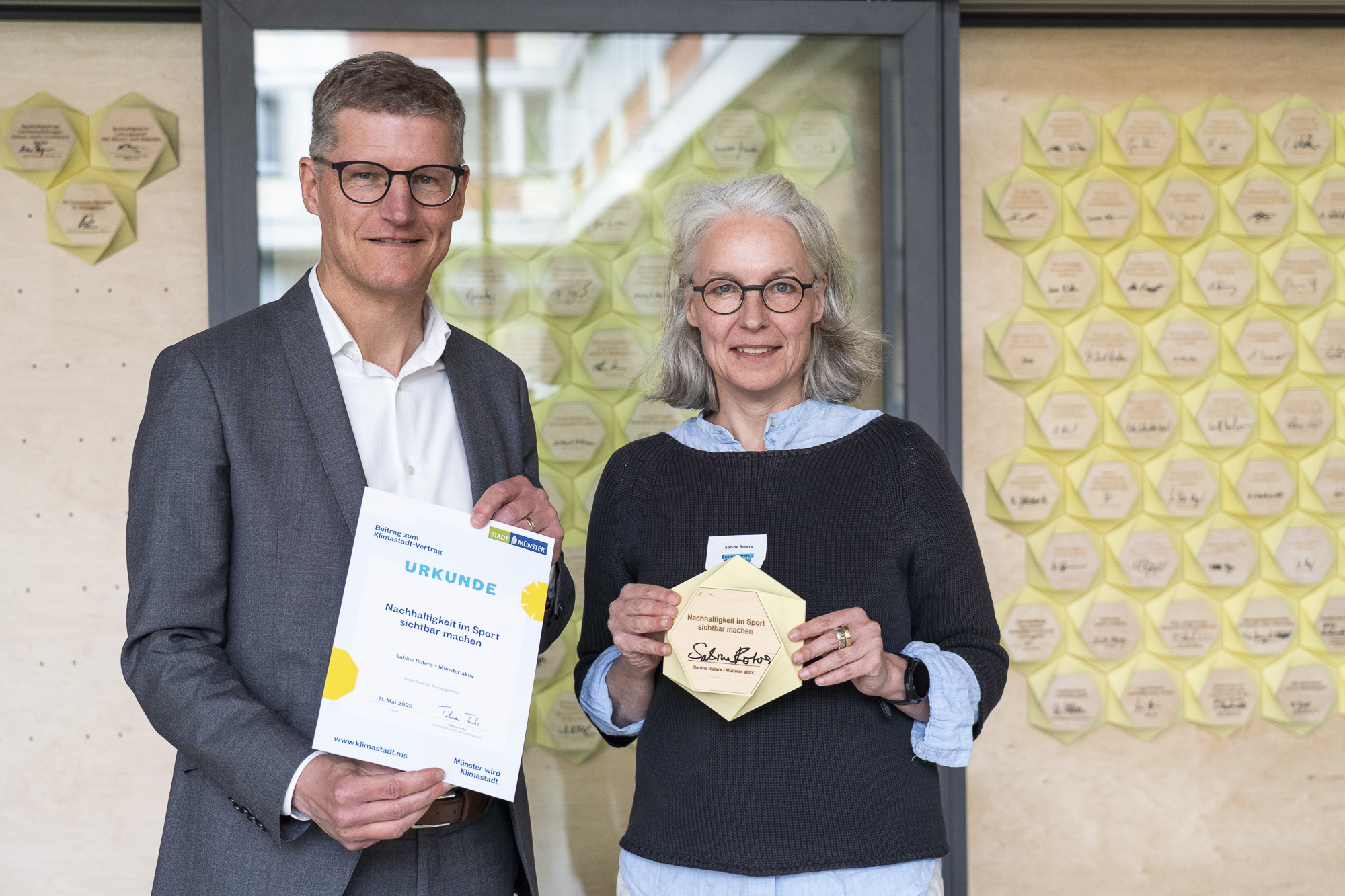 Münsters Oberbürgermeister Tilman Fuchs überreicht eine Urkunde.