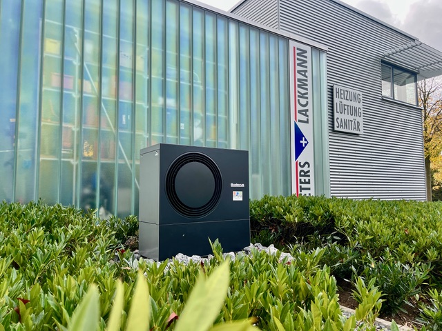 Der Fachbetrieb von außen mit einer Wärmepumpe vor dem Gebäude