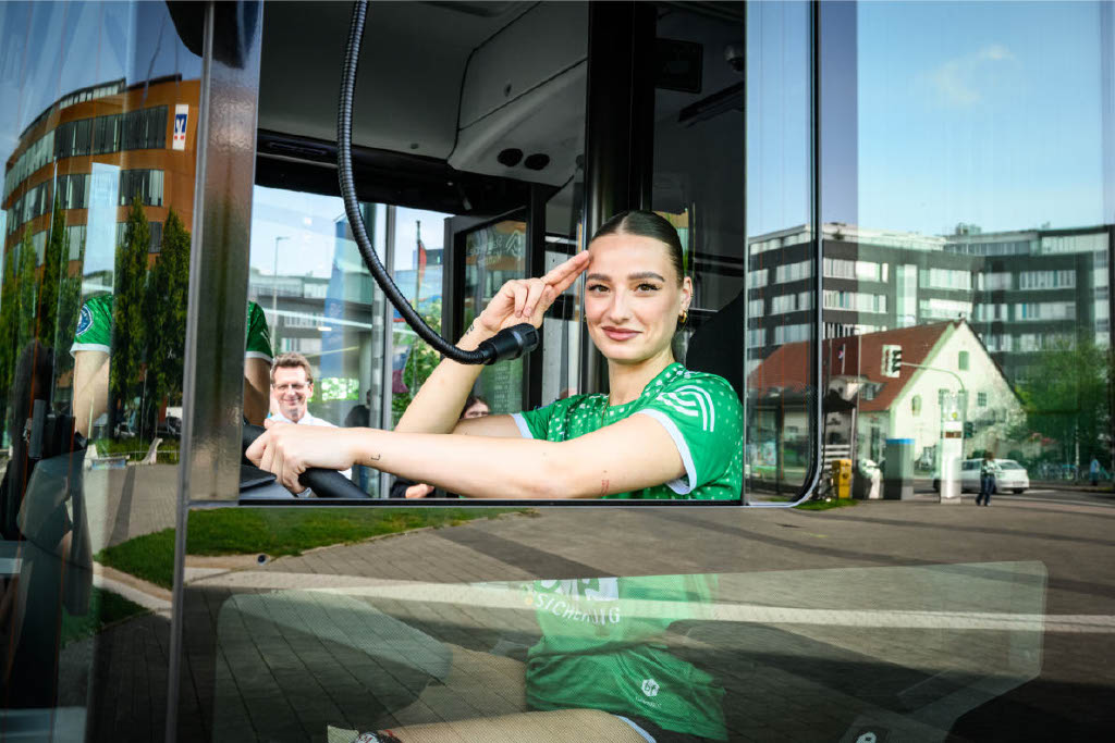 Ein Foto einer Fußballspielerin am Steuer eines Busses