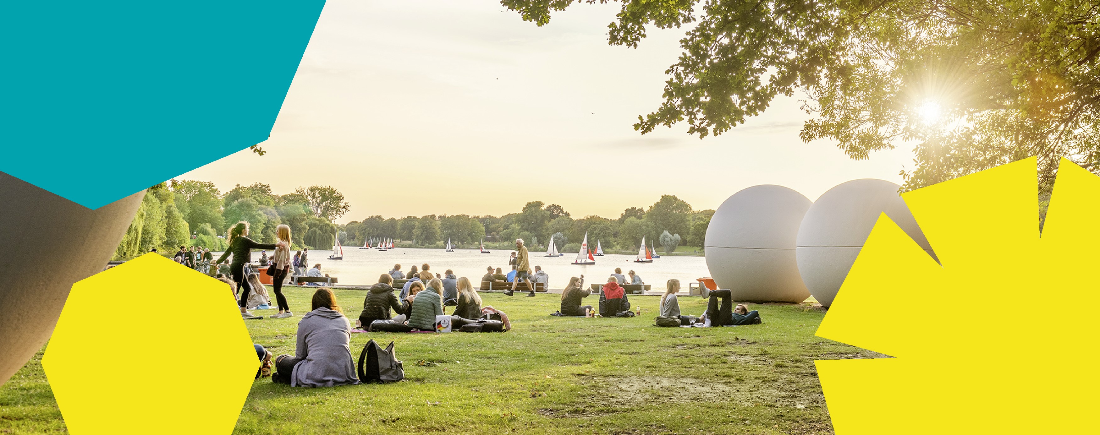 Personen sitzen bei tief stehender Sonne am Aasee