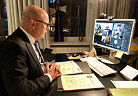 OB Markus Lewe sitzt am Schreibtisch vor dem Monitor bei der laufenden Videokonferenz