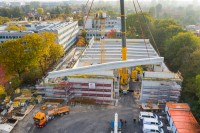 Neubau Dreifachsporthalle am Pascal-Gymnasium Luftaufnahme: Ein Kran bewegt einen der Dachbalken auf das Dach der Sporthalle