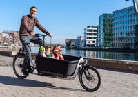 Foto: Presseamt Münster / M. Moeller Mann auf einem Lastenrad mit zwei Kindern in der Transportbox am münsterischen Hafen