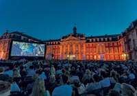 Blick auf Schloss und Leinwand beim Sommernachtskino Publikum vor Leinwand und Schloss