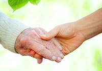 Junge Hand hält alte Hand Zwei Hände liegen ineinander.